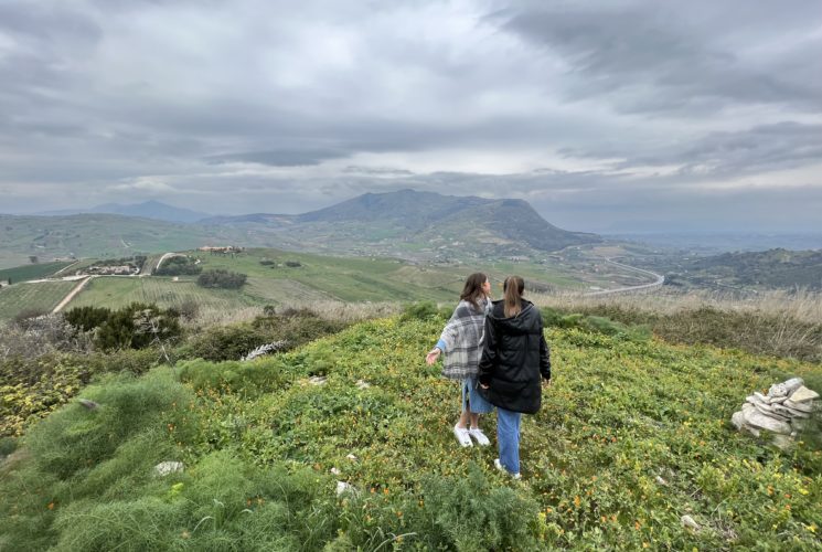 Two students walking in a field.